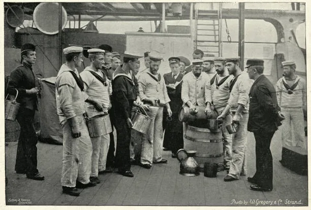 Fotografia d'epoca in bianco e nero di marinai della Royal Navy in fila con i secchielli davanti al barile del Grog sul ponte della HMS Royal Sovereign