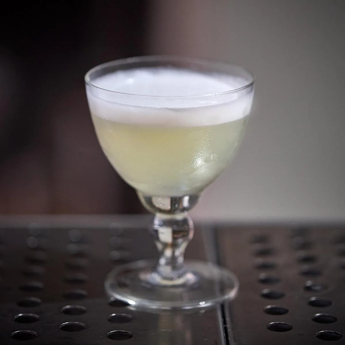 Gin sour in coppetta con uno strato di schiuma bianca compatta ottenuto con 1 cl di aquafaba