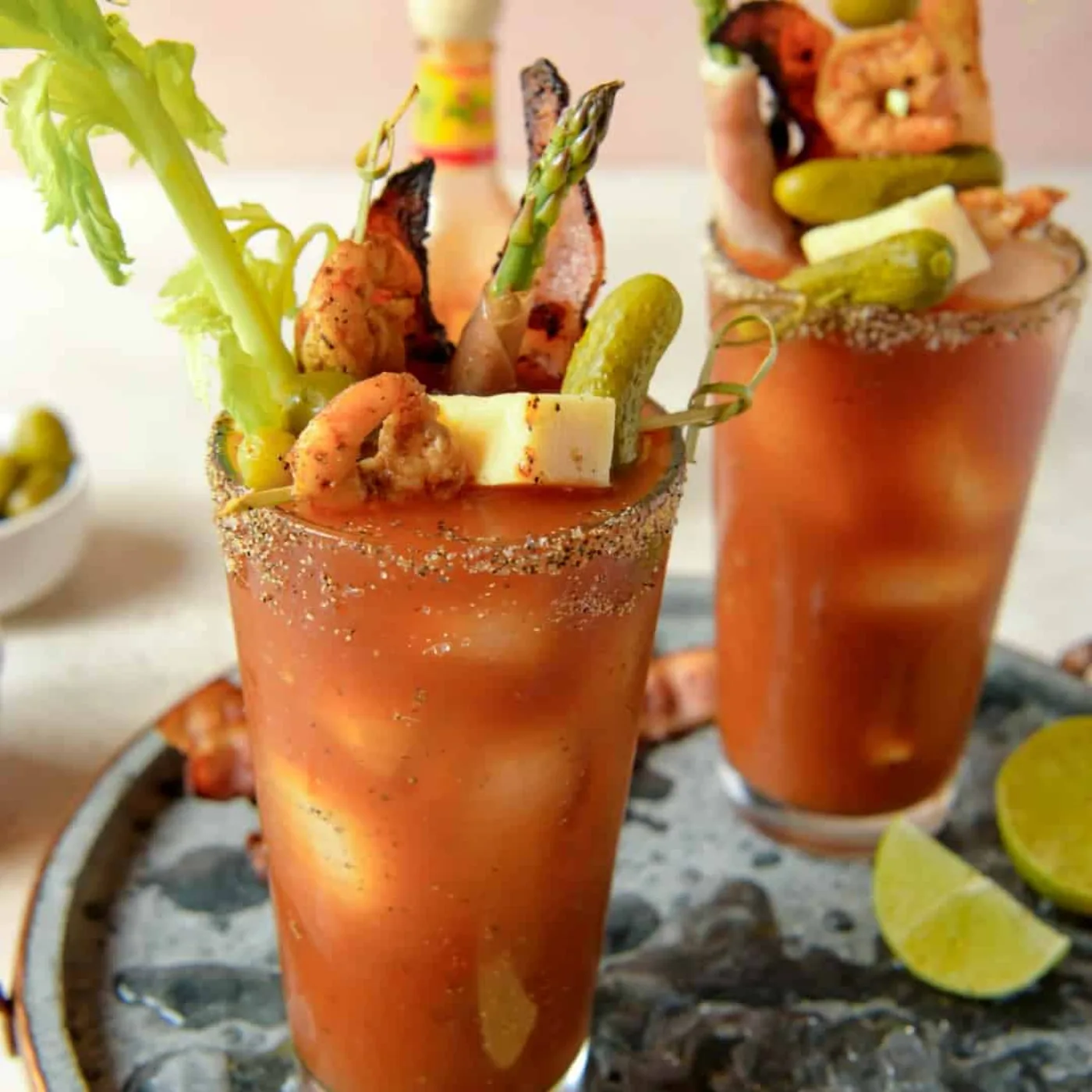 Bloody Mary sovraccarichi di decorazioni con bacon, gamberi, asparagi, cetriolini e formaggio