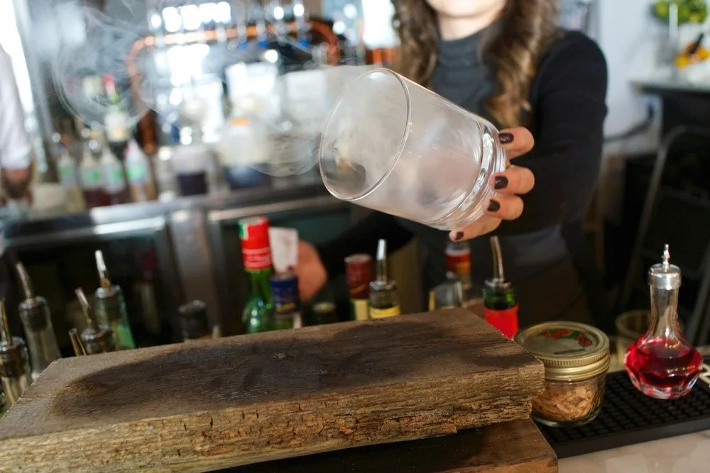 Bicchiere capovolto riempito di fumo prima della preparazione del drink