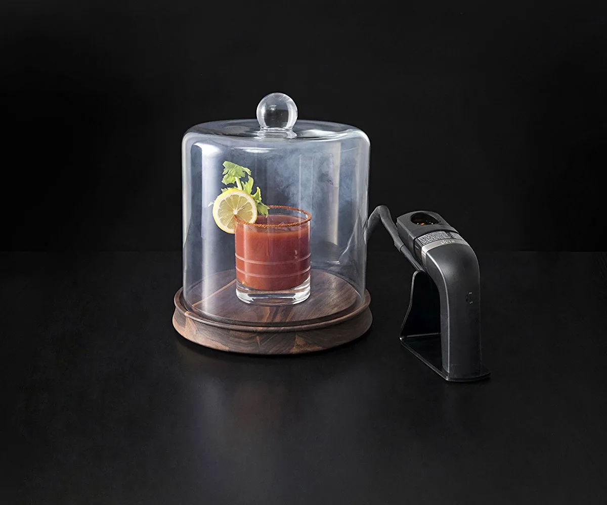 Cocktail servito sotto una campana di vetro piena di fumo