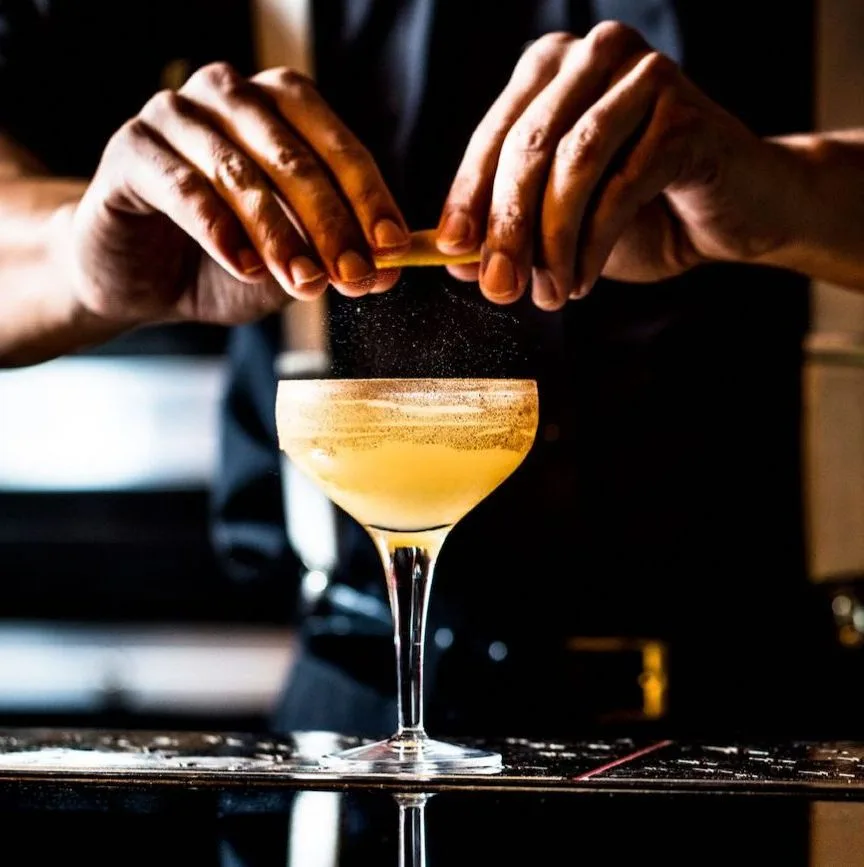 Twist di scorza di limone spremuto sulla superficie di un cocktail