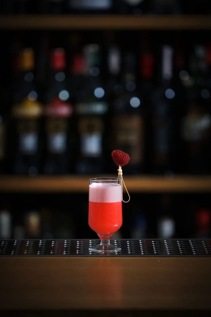 Cocktail sour servito in coppetta con schiuma spessa e uniforme