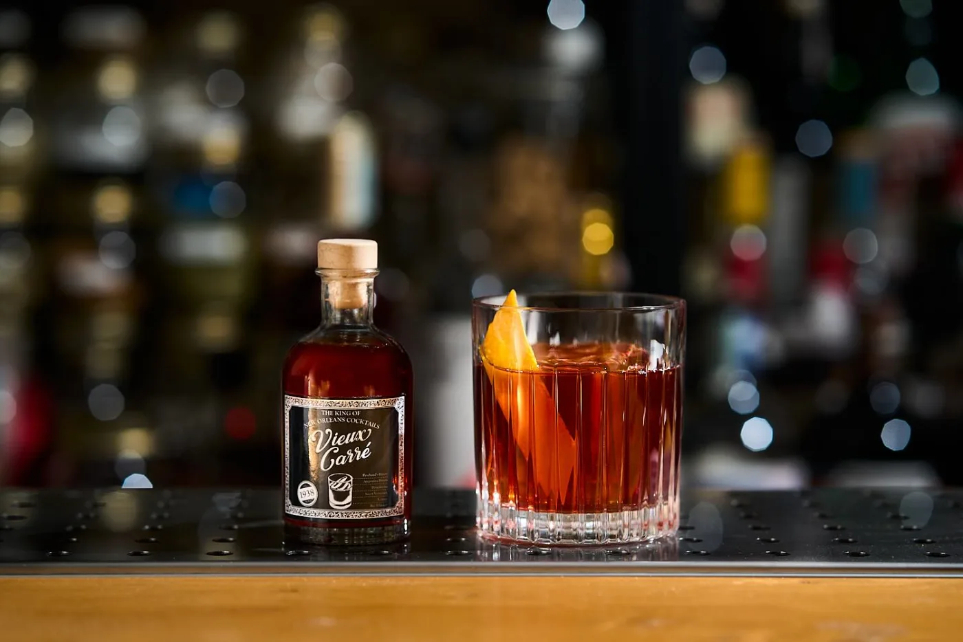 Vieux Carré invecchiato servito in tumbler basso con accanto la bottiglietta etichettata del drink