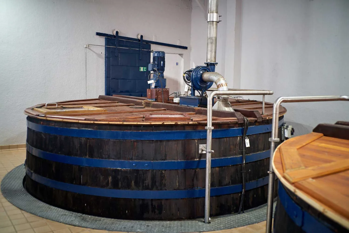 Grandi tini di fermentazione in legno con cerchi blu, con il coperchio di legno chiaro