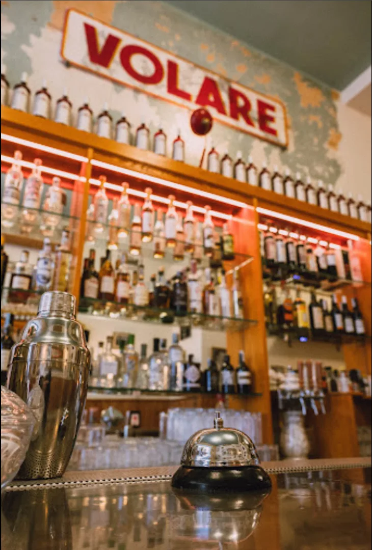 dettaglio del banco bar del bar Volare di Bologna. Sullo sfondo la bottigliera e l'insegna del bar.