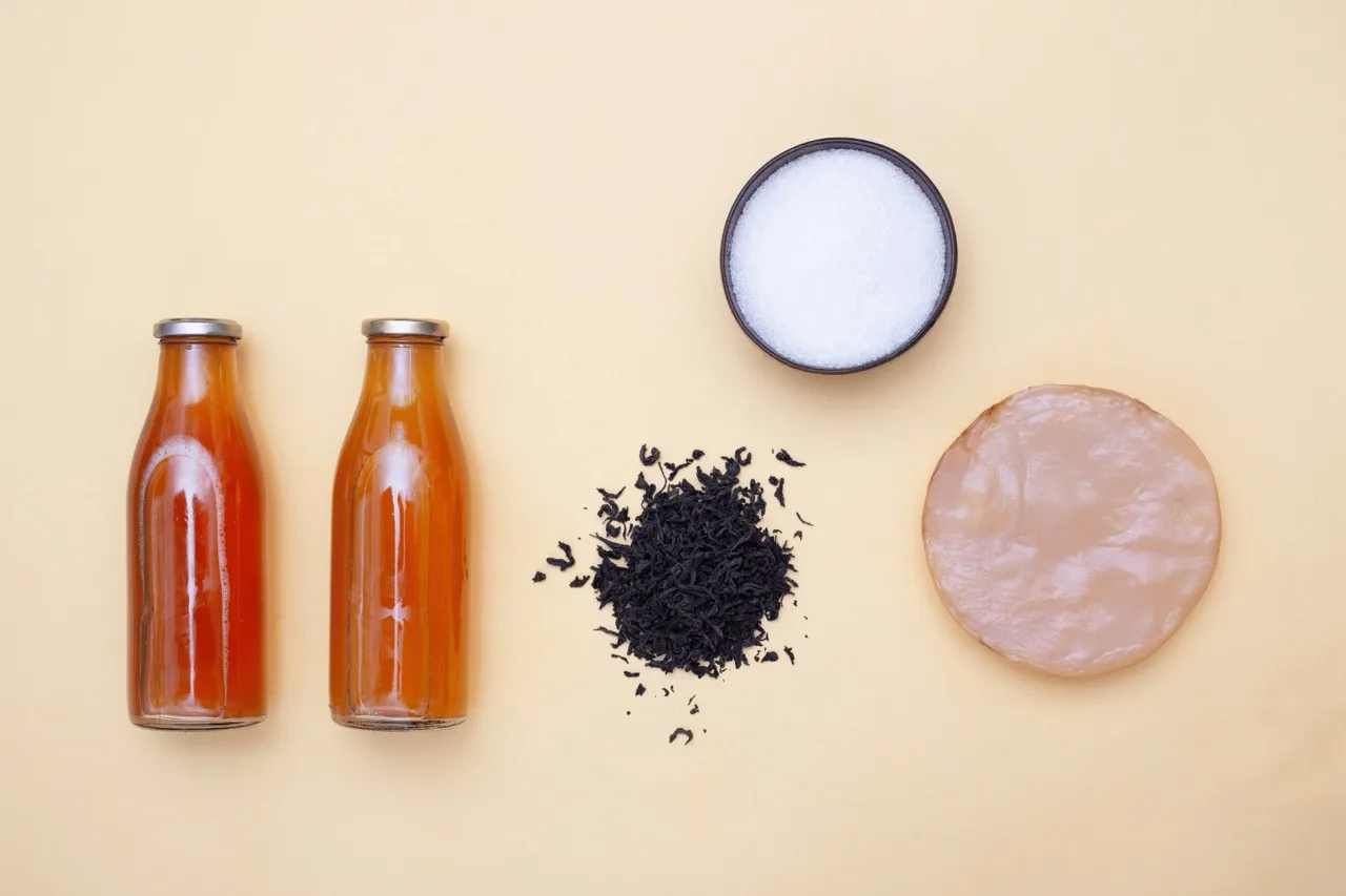 Gli ingredienti del kombucha: due bottiglie di kombucha maturo, tè nero sfuso, zucchero bianco e uno SCOBY