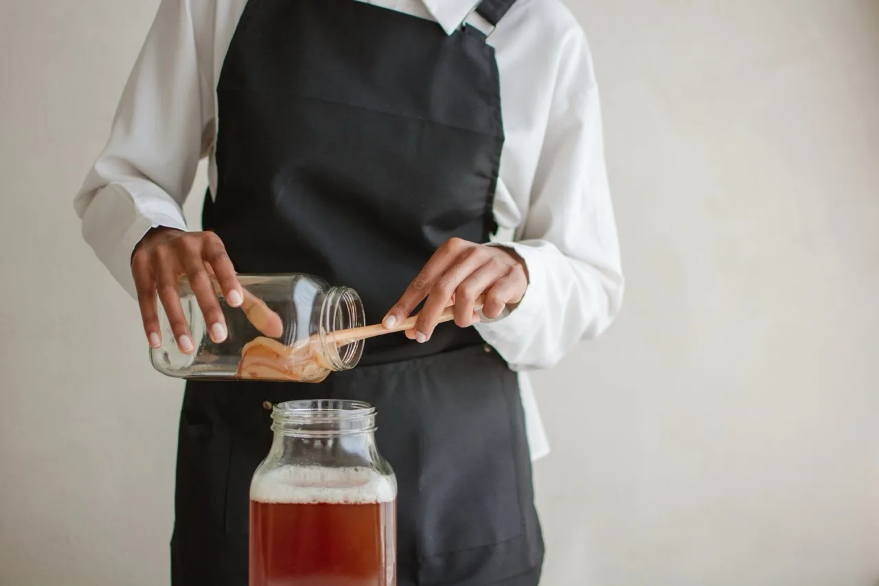 Bartender al lavoro su una preparazione fermentata dietro il bancone