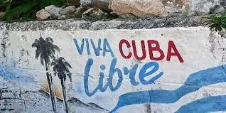 Murale con la scritta Viva Cuba Libre in rosso e blu, con palme e la bandiera cubana