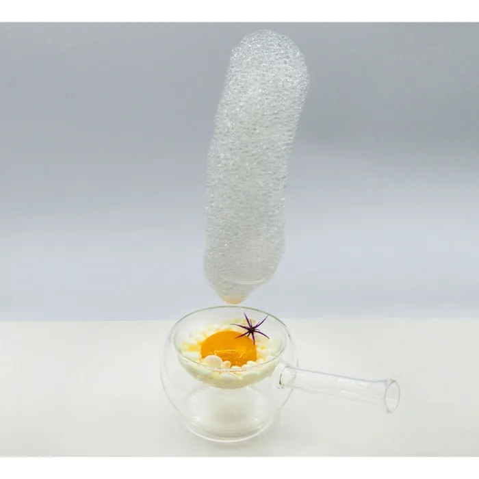 Una schiuma volante all'elio che si solleva da una tazza di vetro con il kit VOM di 100% Chef