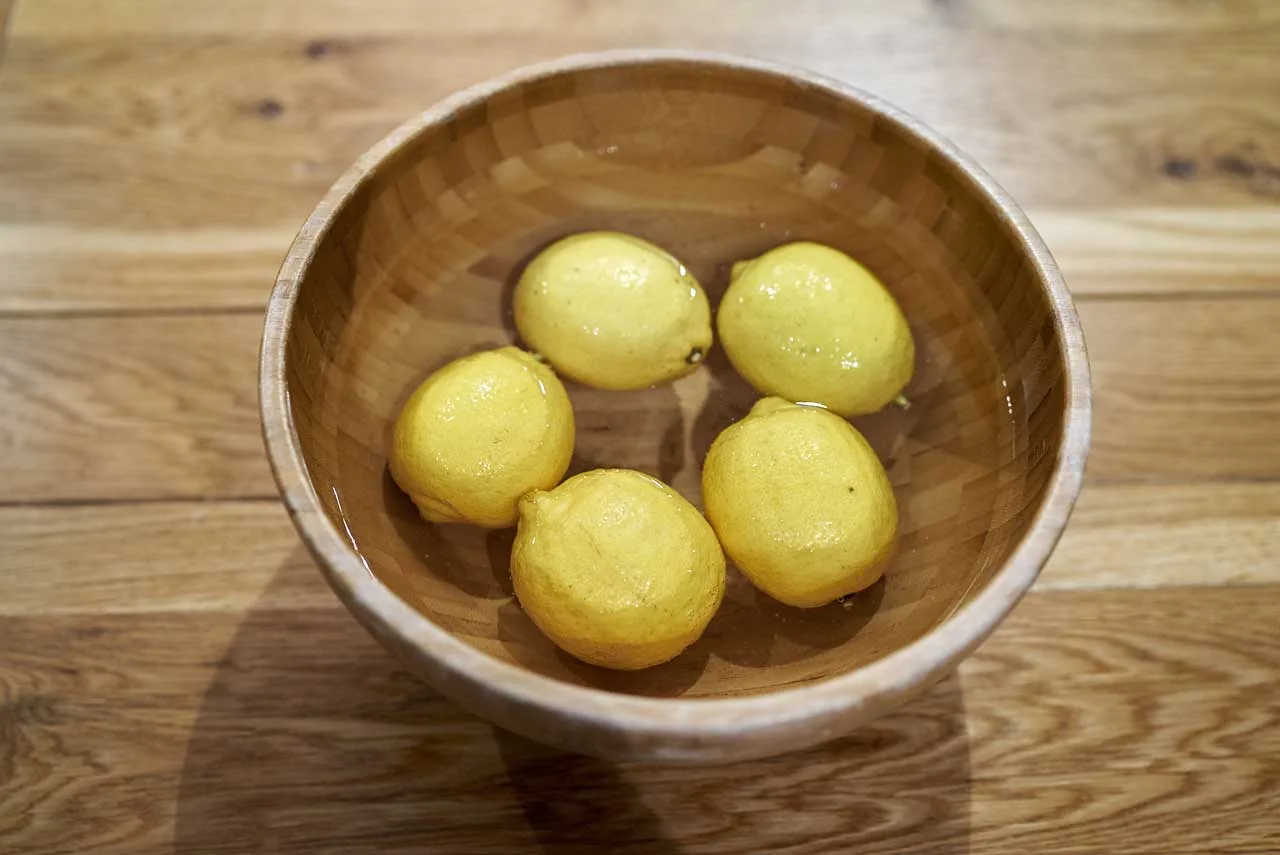 Lavaggio dei limoni sotto acqua corrente prima della preparazione dei limoni marocchini
