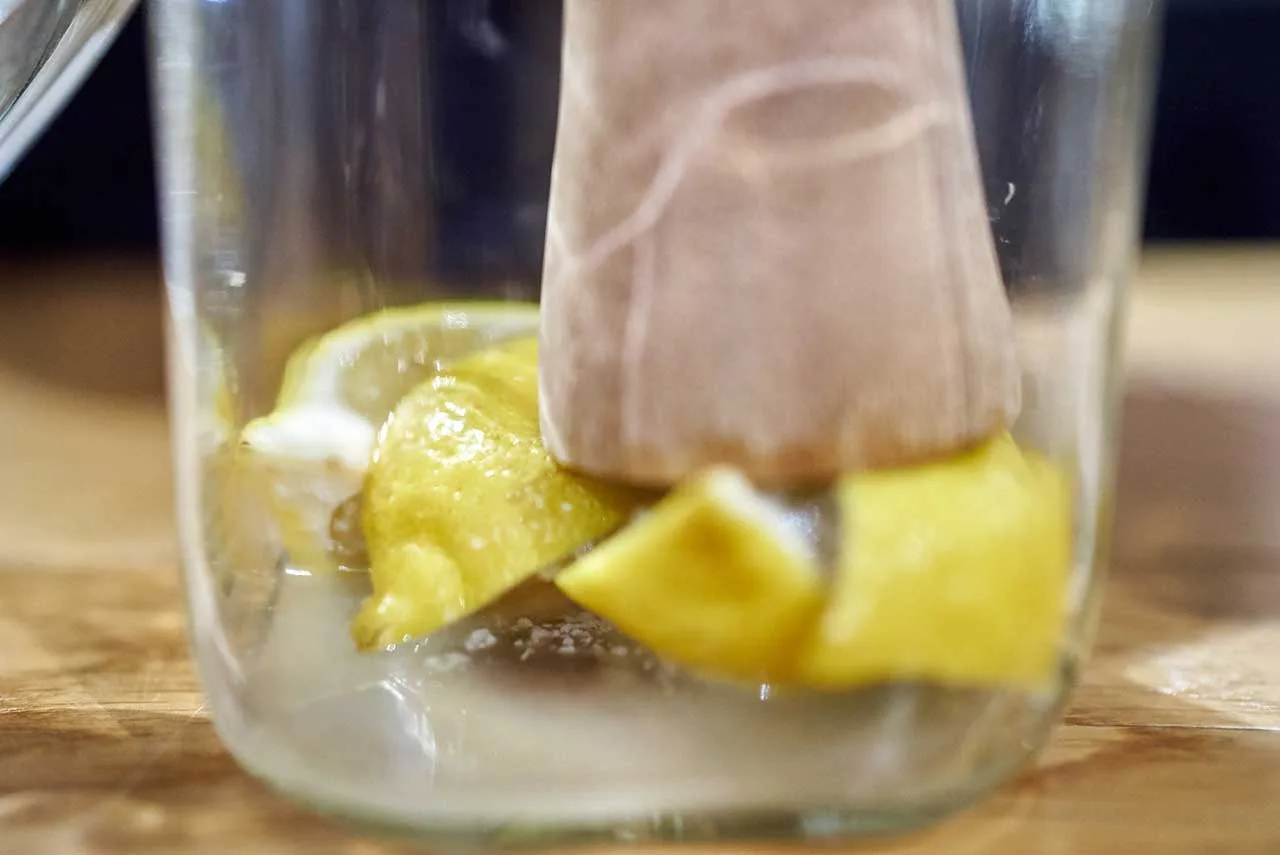 Pressatura dei limoni nel barattolo per far fuoriuscire il succo e sciogliere il sale
