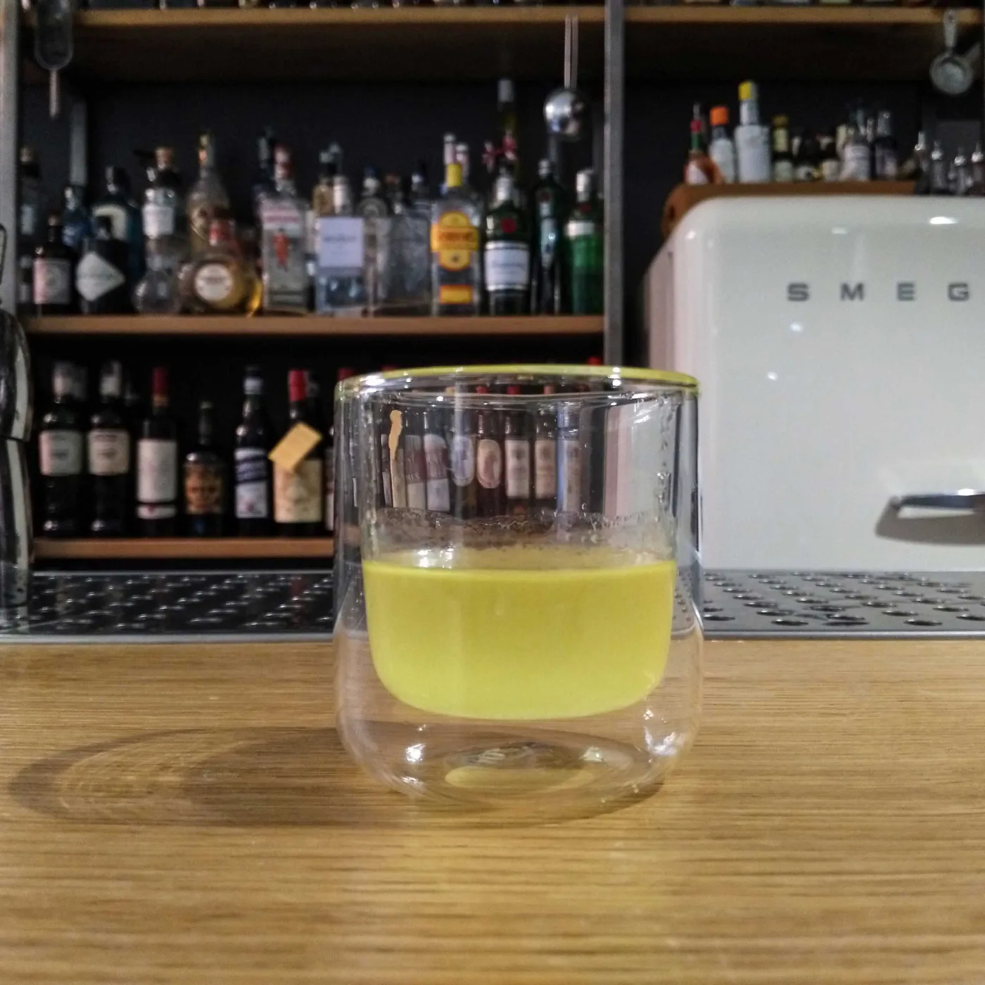 Oleo saccharum liquido di limone in un bicchiere a doppia parete sul banco bar