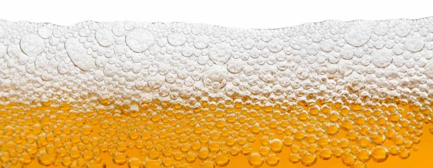 schiuma e bollicine di una birra bionda in primo piano