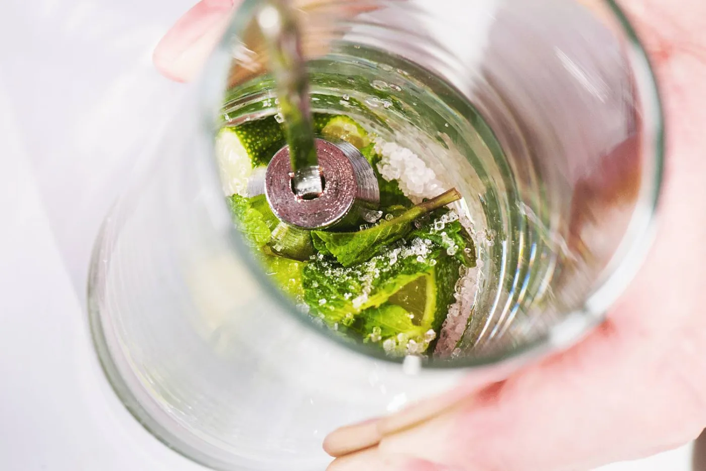 Lime e menta accanto a un pestello: nel Mojito non vanno pestati