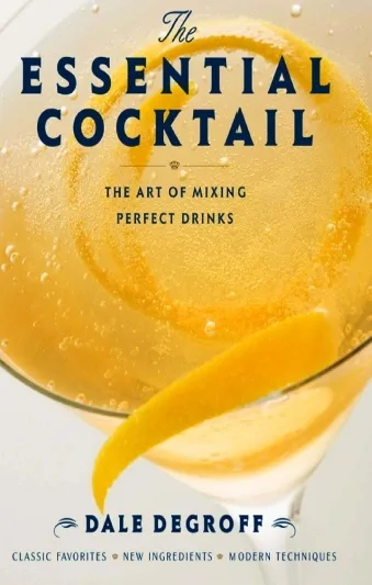 Copertina di The Essential Cocktail di Dale DeGroff con una coppetta e una scorza d'arancia